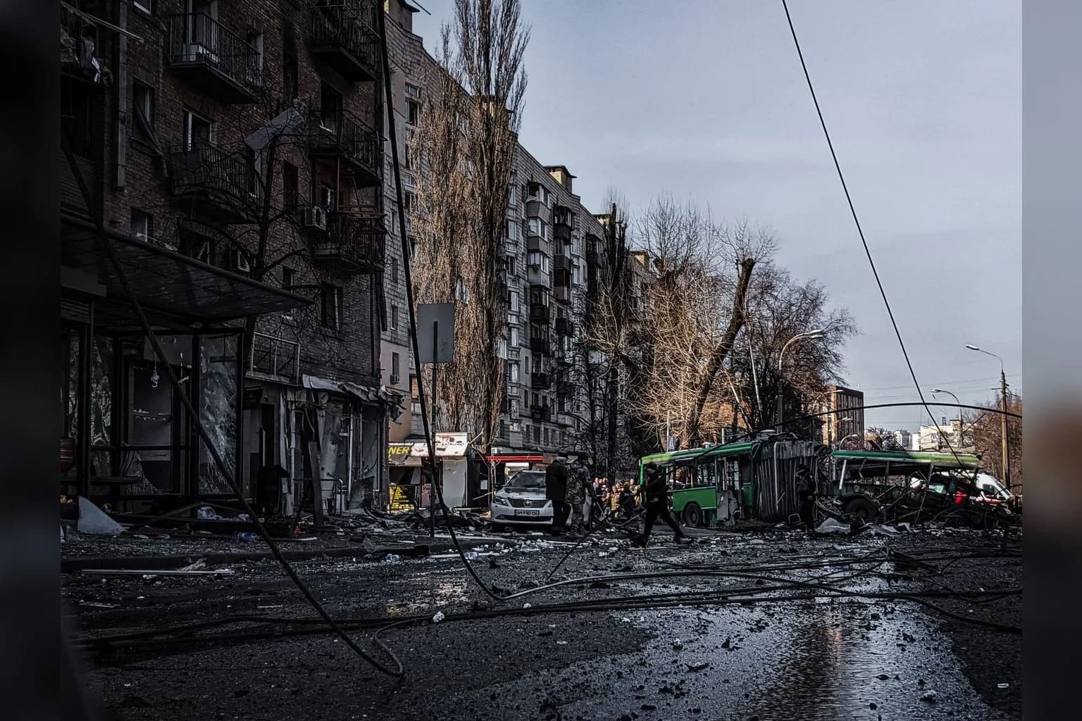 Ukrainian soldiers near the front line in eastern Ukraine, with destroyed buildings visible in the background