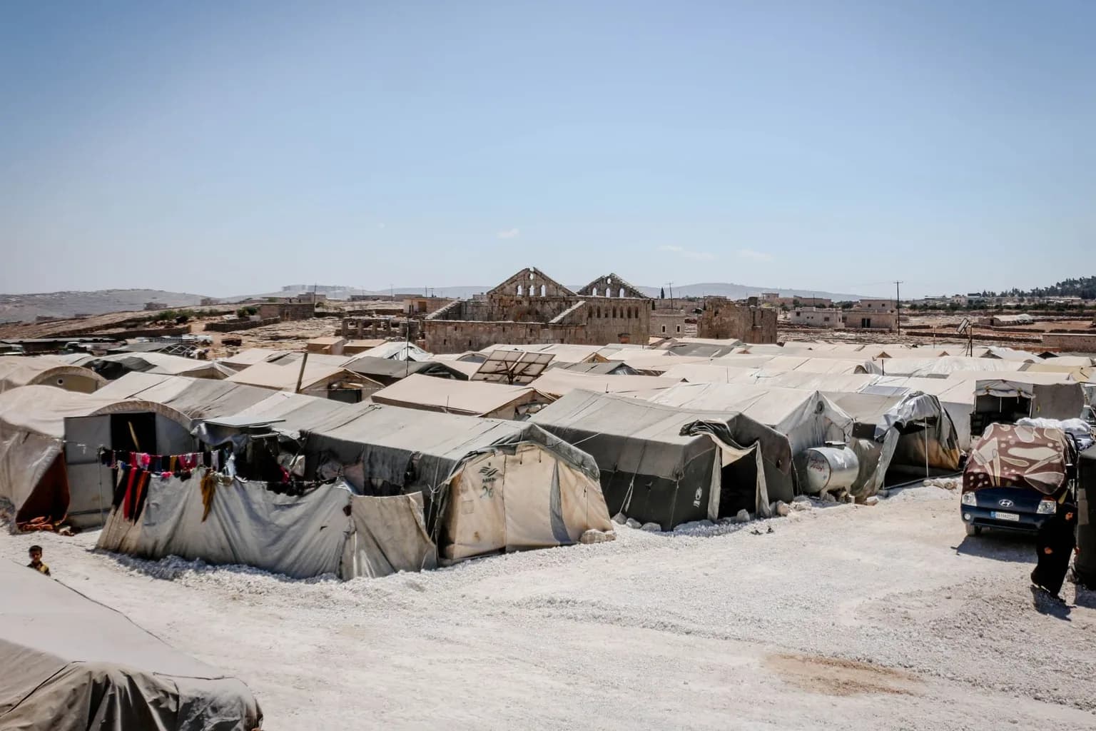 A sparse hospital ward in Yemen with patients on beds and limited medical equipment visible