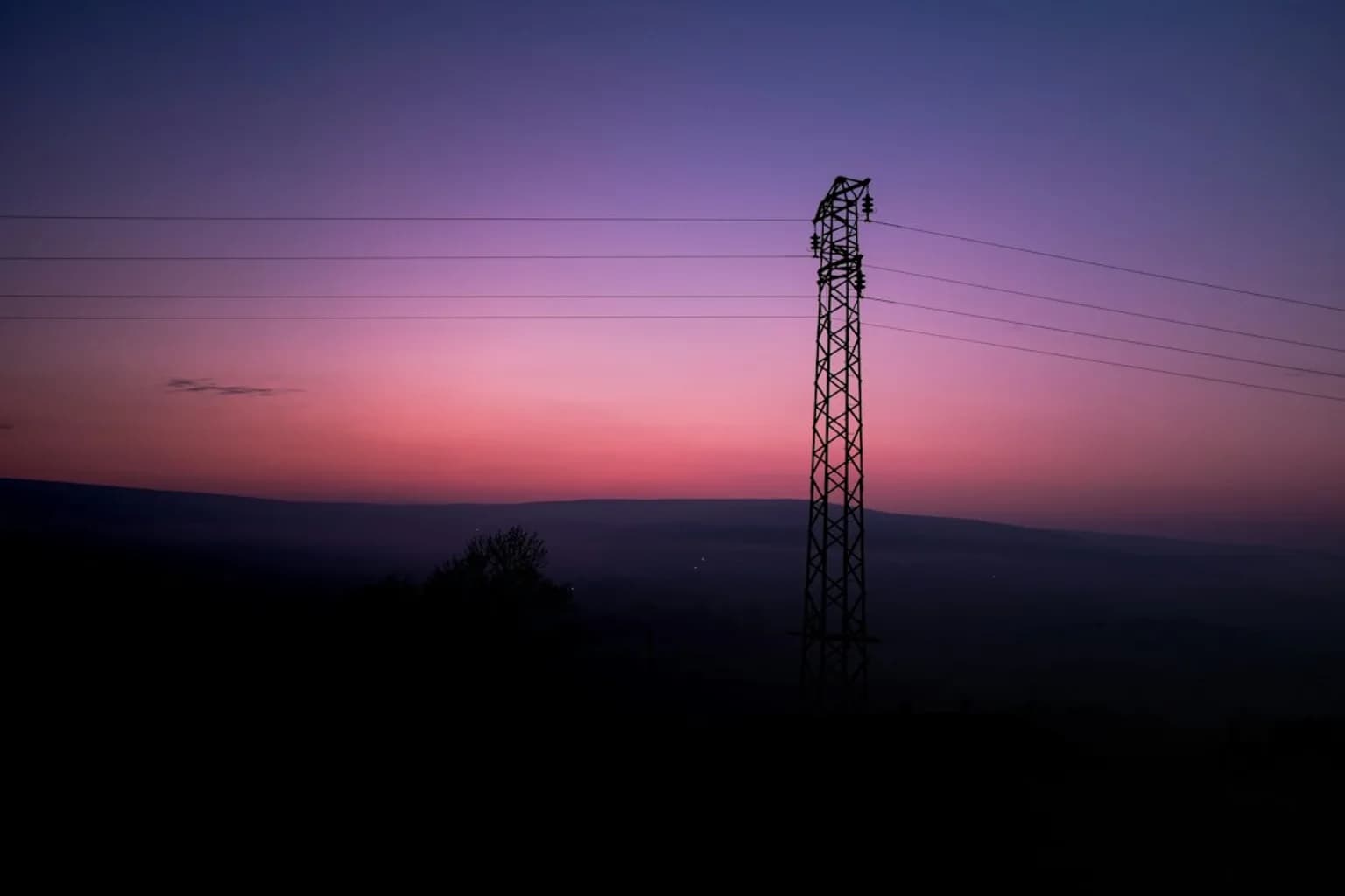 High-voltage electricity transmission pylons crossing open countryside in Great Britain