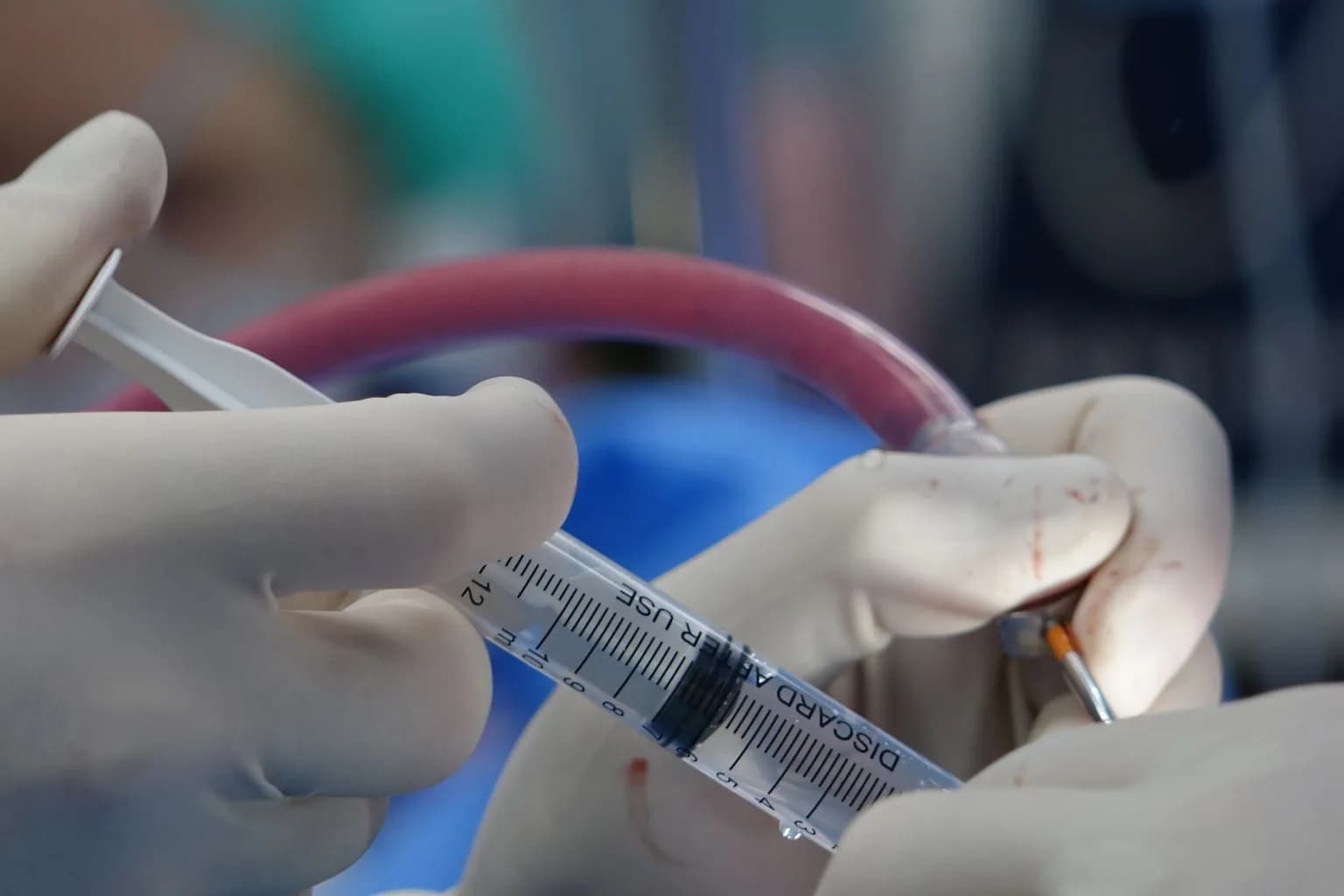 Surgeons operating in a neurosurgery theatre under bright overhead lights