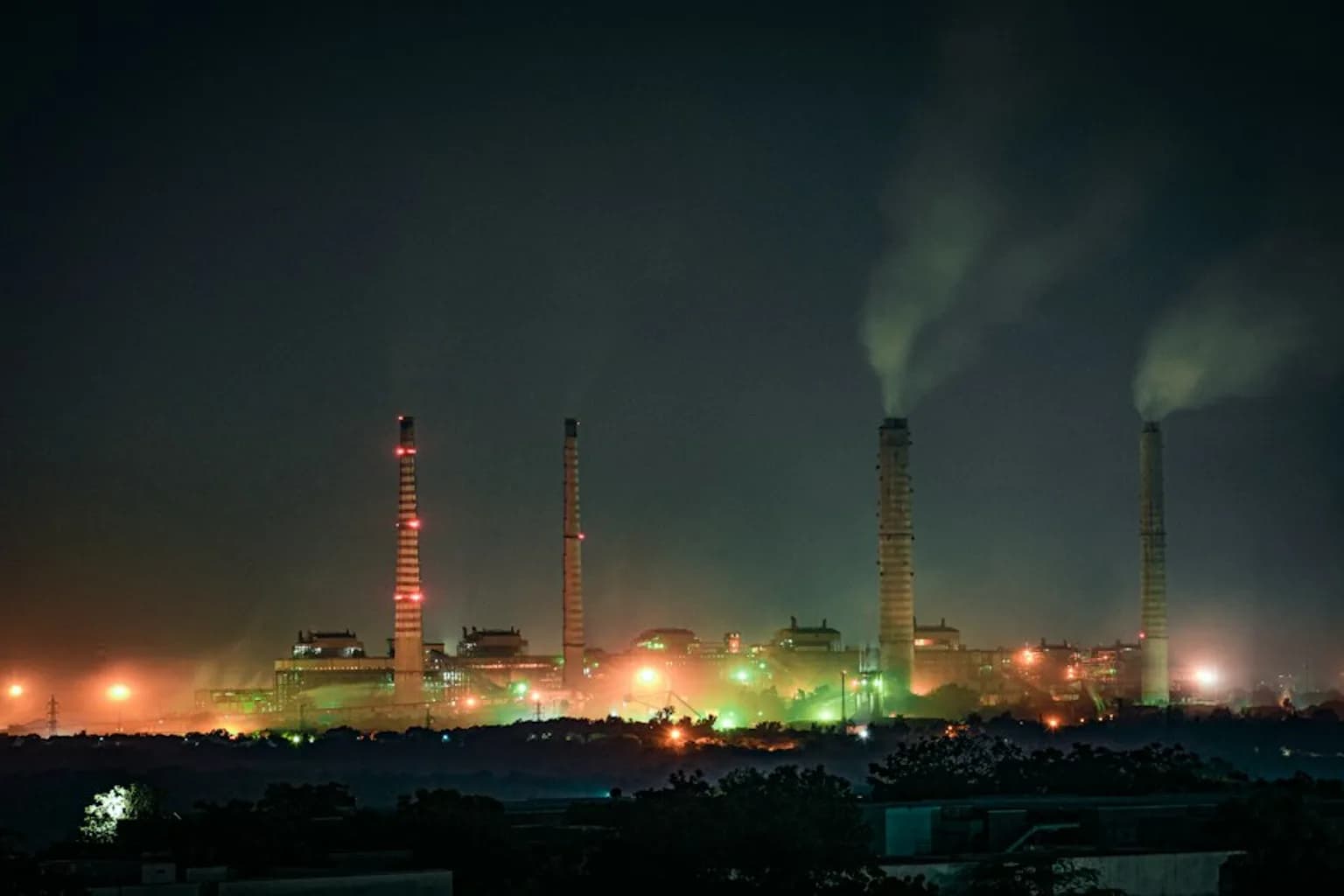 A coal-fired thermal power plant in India with cooling towers emitting steam