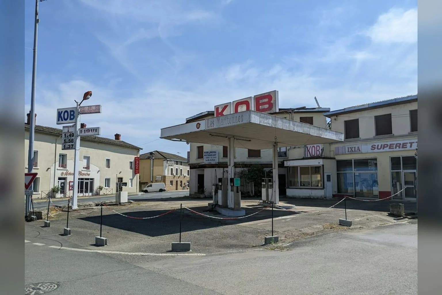 A French petrol station forecourt showing fuel prices on a display board