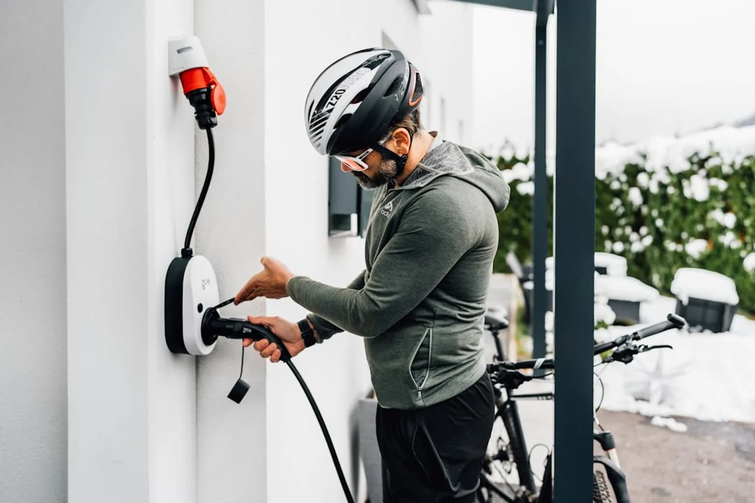 A row of electric cars plugged into charging stations in a European city.
