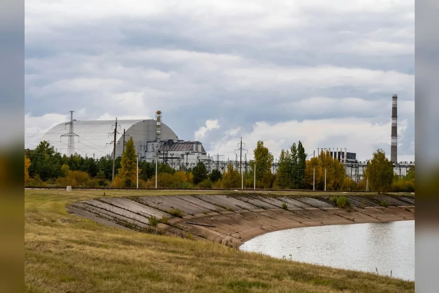 A large natural gas storage facility with cylindrical tanks and pipework in a European industrial setting