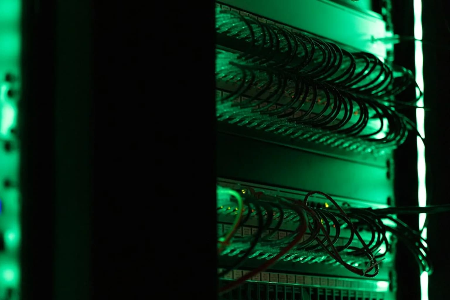 Server racks inside a data centre bathed in blue lighting, representing web infrastructure and cybersecurity risk