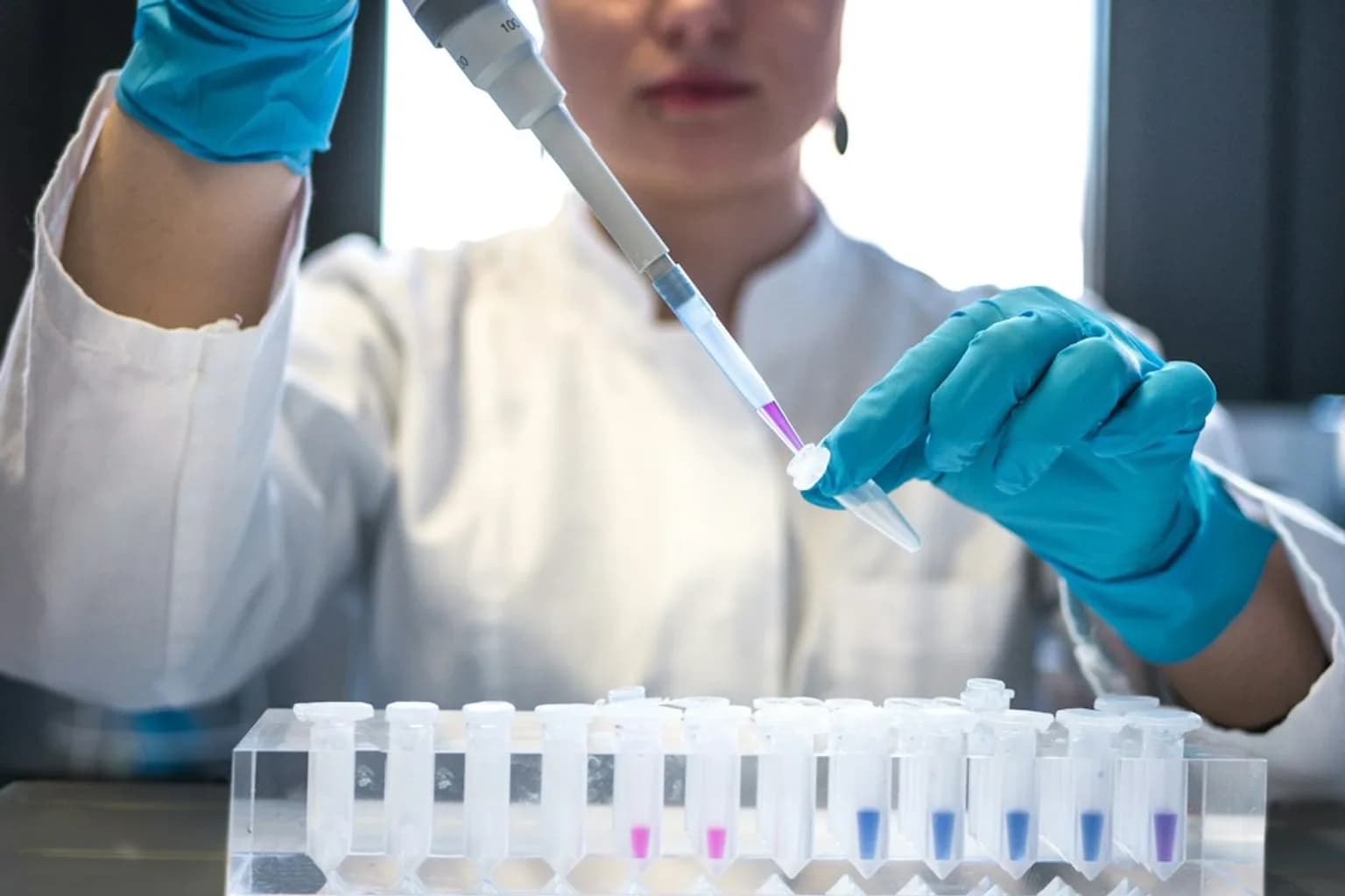 Researcher working at a molecular biology laboratory bench with scientific equipment used in protein research
