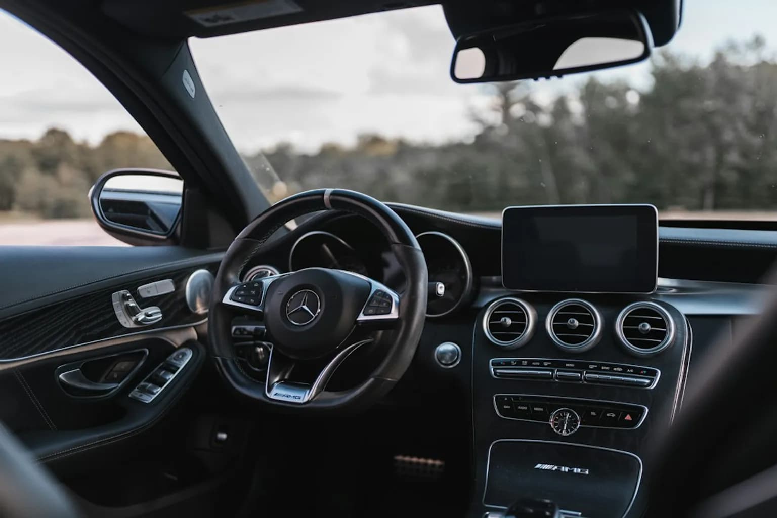 A touchscreen infotainment display inside a modern connected vehicle showing navigation and app interfaces.