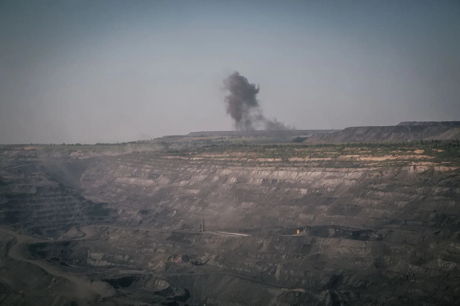 An open-pit mining site in Karaganda Oblast, Kazakhstan, with industrial machinery and excavated terrain visible against a wide steppe landscape.