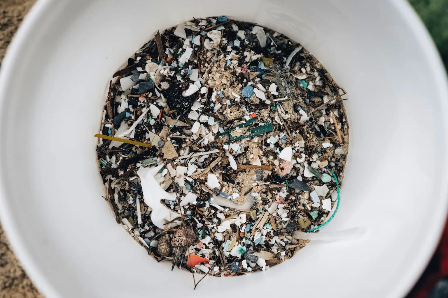 Close-up of soil sample containing visible microplastic particles collected from an agricultural field