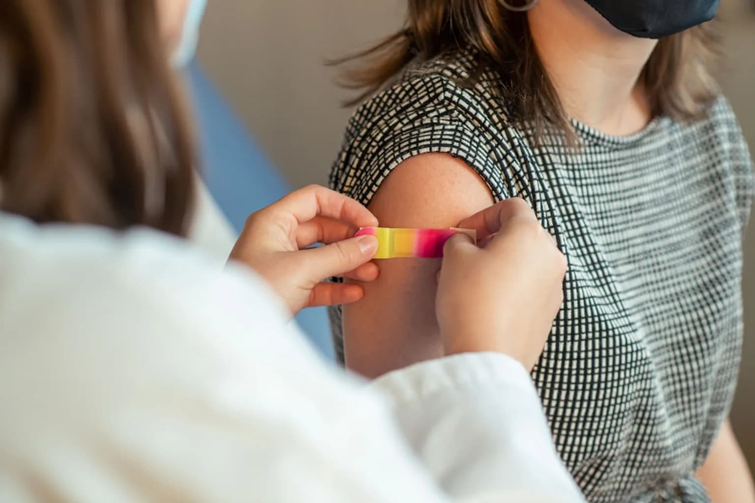A young child receiving an MMR vaccination injection from a healthcare worker